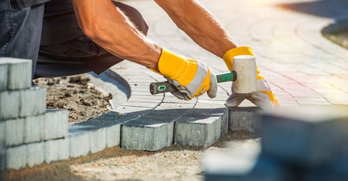 Construction worker laying paver blocks